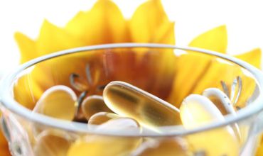 clear glass bowl with supplements services and flower framing the bowl in the background